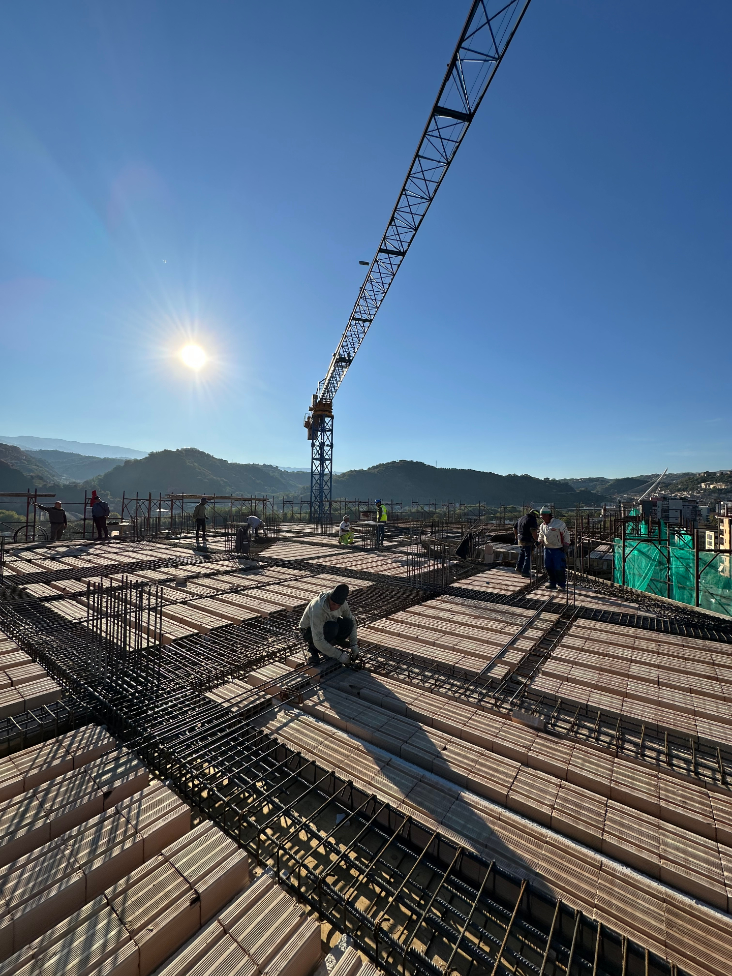 Cantiere edile con operai al lavoro sull'armatura di un solaio in costruzione